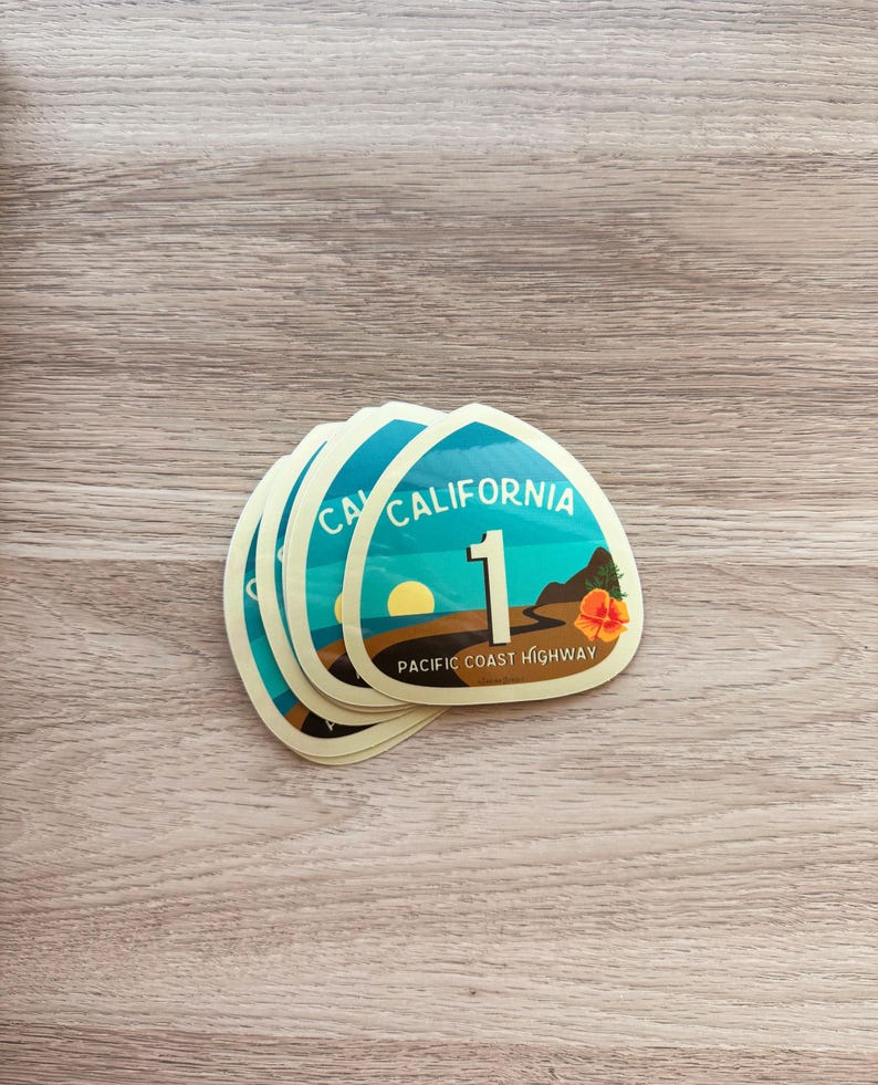 May include: A stack of five yellow and blue California Highway 1 stickers with the text "PACIFIC COAST HIGHWAY" on the bottom.