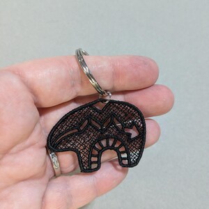 May include: Black lace bear keychain with a silver key ring.