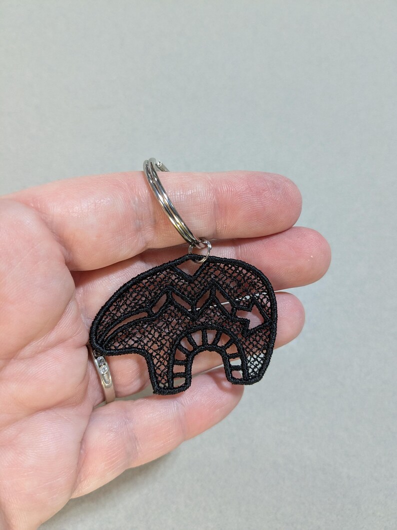 May include: Black lace bear keychain with a silver key ring.
