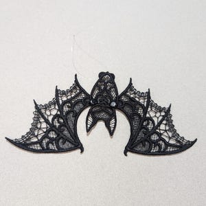 May include: Black lace bat ornament with a beaded eye detail.