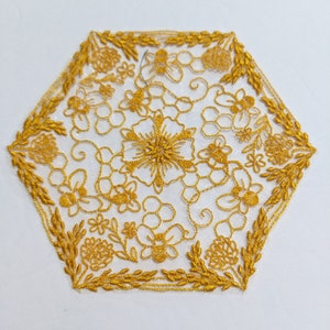 May include: Gold embroidered hexagonal lace with a floral and honeycomb design. The lace features bees and flowers.