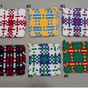 May include: Six handmade woven pot holders in various color combinations. Designs include red and white, yellow and blue, purple and white, black, red, and white, blue, green, and white, and green, red, and yellow. Each has a loop for hanging.