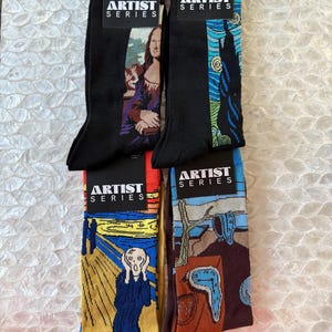 May include: Four pairs of black socks with colorful artwork featuring famous paintings. The socks have the words "Artist Series" printed on the tags. The paintings include "Mona Lisa", "The Starry Night", "The Scream", and "The Persistence of Memory".
