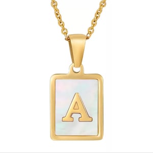 May include: Gold chain necklace with a square pendant featuring a white mother-of-pearl inlay and the letter 'A' in gold.