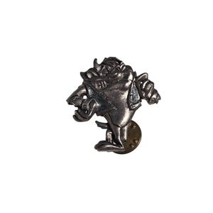 Könnte beinhalten: Eine silberfarbene Metallnadel mit einer Cartoonfigur mit grimmigem Gesichtsausdruck. Die Nadel zeigt ein Wesen mit Hörnern, einem breiten Mund und einer Jacke. Die Nadel hat eine goldfarbene Rückseite.