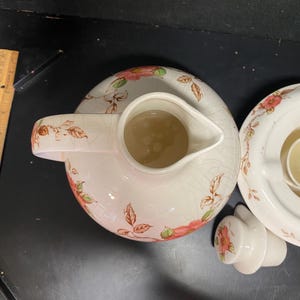 Nasco "Springtime" teapot or coffee carafe, likely from the 1940s, matching lidded pitcher and a warming stand.