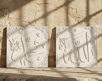 May include: Two off-white square wall art pieces with Arabic calligraphy. Each piece features intricate carved details and a decorative border. The art is displayed on a stone surface, with sunlight casting shadows.