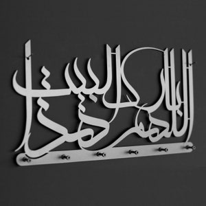 K&ouml;nnte beinhalten: Ein silberner, wandmontierter Schl&uuml;sselhalter aus Metall mit dem arabischen Ausdruck "Allah" in dekorativer Schrift. Der Halter hat sechs Haken zum Aufh&auml;ngen von Schl&uuml;sseln.