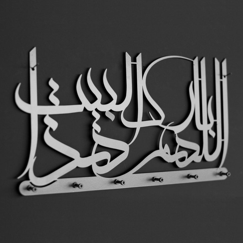 K&ouml;nnte beinhalten: Ein silberner, wandmontierter Schl&uuml;sselhalter aus Metall mit dem arabischen Ausdruck "Allah" in dekorativer Schrift. Der Halter hat sechs Haken zum Aufh&auml;ngen von Schl&uuml;sseln.