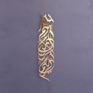 Op de afbeelding: Gouden metalen wandkunst met ingewikkelde Arabische kalligrafie. Het ontwerp is een verticale opstelling van vloeiende schrift.