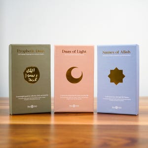 K&ouml;nnte beinhalten: Drei Hardcover-B&uuml;cher mit den Titeln: "Prophetic Duas", "Duas of Light" und "Names of Allah". Das erste Buch ist olivgr&uuml;n mit arabischer Kalligraphie. Das zweite ist pfirsichfarben mit einem Halbmond. Das dritte ist hellblau mit einem achtzackigen Stern.