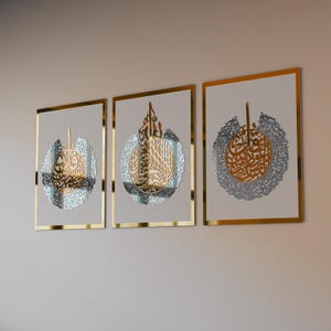 May include: Three gold framed wall art pieces with intricate silver calligraphy designs. The designs are circular and feature Arabic script.