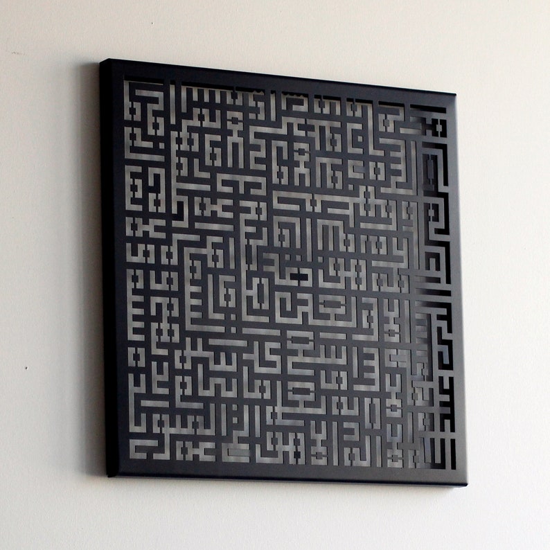 May include: A black metal wall art piece with a geometric design featuring a repeating pattern of squares and rectangles. The design is cut out of the metal, creating a shadow effect.