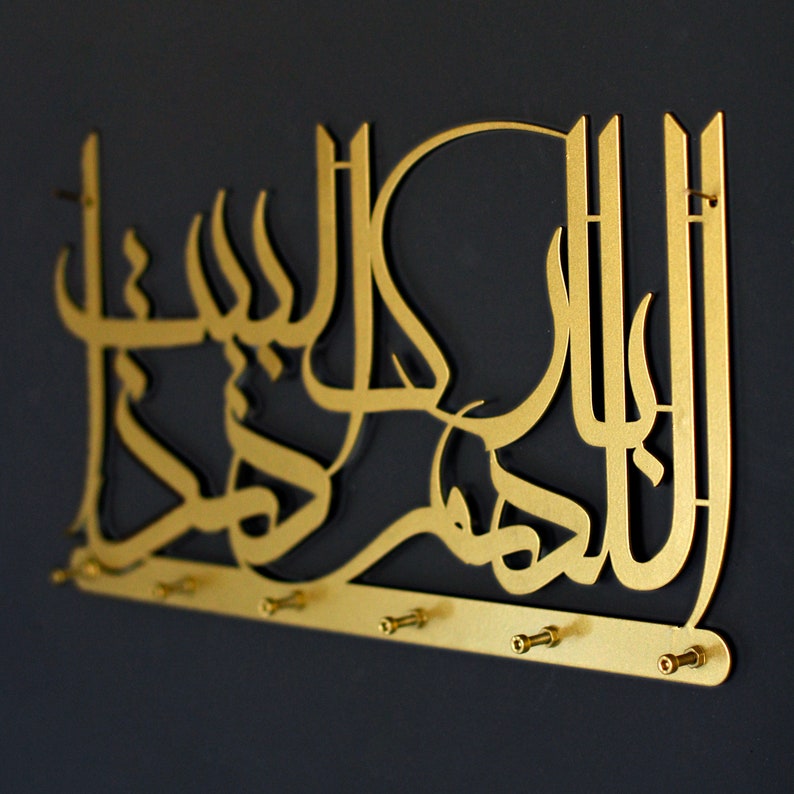 K&ouml;nnte beinhalten: Goldfarbener, wandmontierter Schl&uuml;sselhalter aus Metall mit arabischer Kalligraphie und Haken. Die Kalligraphie lautet "Allah", das arabische Wort f&uuml;r Gott.