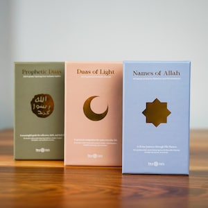 K&ouml;nnte beinhalten: Drei Hardcover-B&uuml;cher mit goldfarbenen Akzenten. Die B&uuml;cher sind in Gr&uuml;n-, Pfirsich- und Blaut&ouml;nen gehalten. Die Titel lauten "Prophetic Duas", "Duas of Light" und "Names of Allah". Jedes Buch hat ein anderes Symbol: arabischer Text, ein Mond und ein Stern.