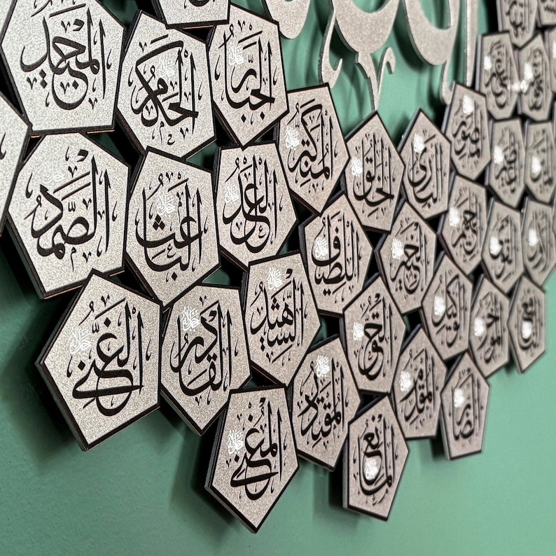 Peut inclure: Une &oelig;uvre d'art murale islamique argent&eacute;e et noire avec un motif d&eacute;coratif de multiples formes hexagonales avec de la calligraphie arabe. Les formes sont dispos&eacute;es en un motif semi-circulaire.