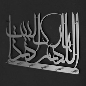 K&ouml;nnte beinhalten: Ein silberner Schl&uuml;sselhalter aus Metall mit dem arabischen Ausdruck "Allah" in einer dekorativen, stilisierten Schrift. Der Halter hat eine Reihe von Haken zum Aufh&auml;ngen von Schl&uuml;sseln.