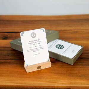 K&ouml;nnte beinhalten: Ein Satz Prophetic Duas-Karten mit arabischem Text und englischer &Uuml;bersetzung, pr&auml;sentiert auf einem Holzst&auml;nder. Die Karten sind wei&szlig; mit einer gr&uuml;nen Box, und der Text enth&auml;lt die Worte "Prophetic Duas".