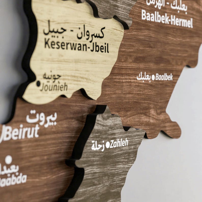 May include: A wooden map of Lebanon with the names of different regions labelled in both Arabic and English. The regions include Baalbek-Hermel, Keserwan-Jbeil, Beirut, Zahleh, and Jounieh.