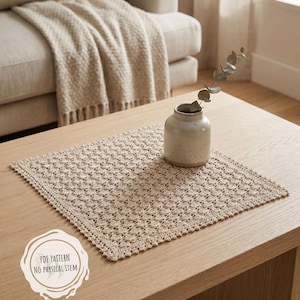 May include: A beige crocheted placemat with a detailed openwork pattern sits on a light wood coffee table. A small ceramic vase with a sprig of greenery is next to the placemat. The text on the image says "PDF PATTERN NO PHYSICAL ITEM".