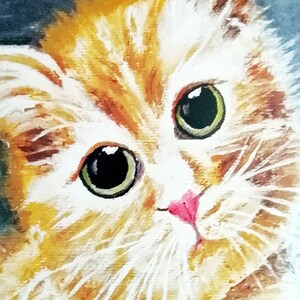 May include: A close-up of a white and orange cat with green eyes. The cat is looking directly at the viewer with a curious expression.