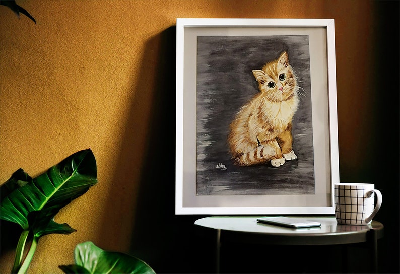 May include: A framed watercolor painting of a ginger kitten sitting on a gray background. The kitten has green eyes and is looking directly at the viewer.