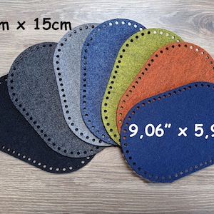 Può includere: Un set di sei pezzi di feltro ovali in vari colori, tra cui nero, grigio, blu, verde, arancione e un grigio più chiaro. I pezzi di feltro hanno un bordo cucito e misurano 9,06 pollici per 5,91 pollici.