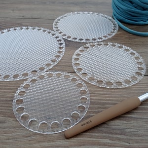 Può includere: Quattro cerchi di uncinetto rotondi in plastica di diverse dimensioni, un gomitolo di filo turchese e un uncinetto marrone con la scritta "8.00 mm" sul manico.