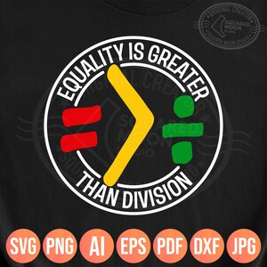 Könnte beinhalten: Ein schwarzes T-Shirt mit einem weißen Kreis-Motiv. Das Motiv zeigt den Text "EQUALITY IS GREATER THAN DIVISION" in einem weißen Kreis mit einem gelben Pfeil, der nach rechts zeigt, einem roten Gleichheitszeichen und einem grünen Divisionssymbol.
