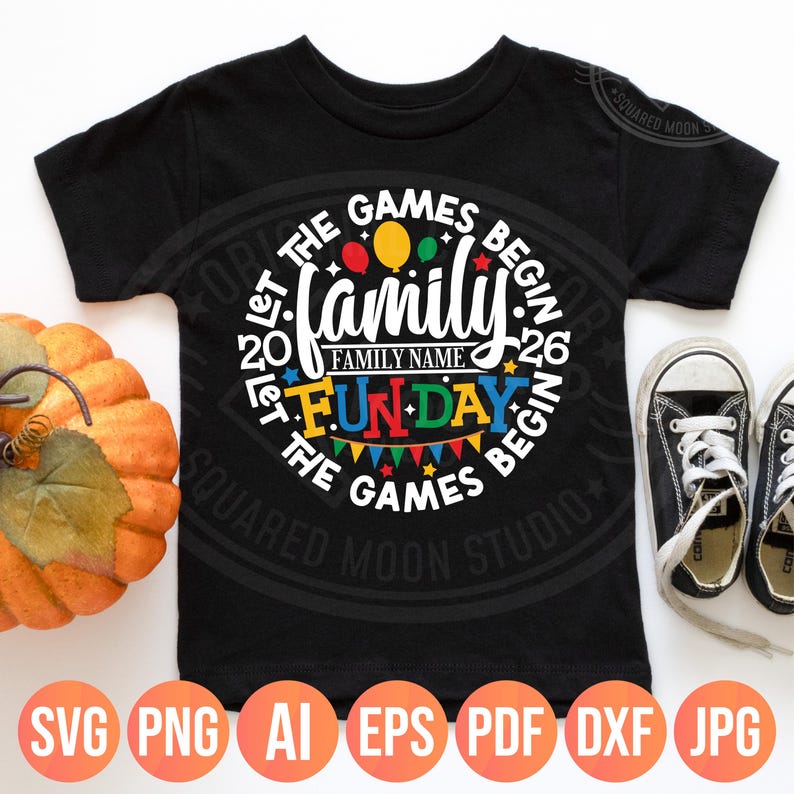 May include: Black t-shirt with a circular design that reads "Family Fun Day" with colorful balloons and bunting. The text "Let the Games Begin" surrounds the design. The shirt also has the text "Family Name" and the numbers "20" and "26".