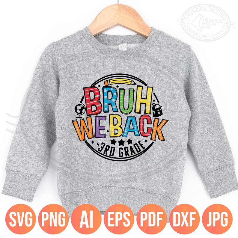 May include: A gray sweatshirt with the text "BRUH WE BACK 3RD GRADE" in a colorful, circular design. The design includes a pencil, globe, backpack, and stars. The sweatshirt is displayed on a wooden hanger.