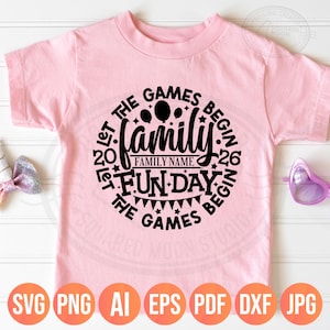 May include: A light pink t-shirt with a black circular design that reads "Let the Games Begin" around the word "Family". The design includes balloons, stars, and a banner. The bottom of the shirt has the file types: SVG, PNG, AI, EPS, PDF, DXF, and JPG.