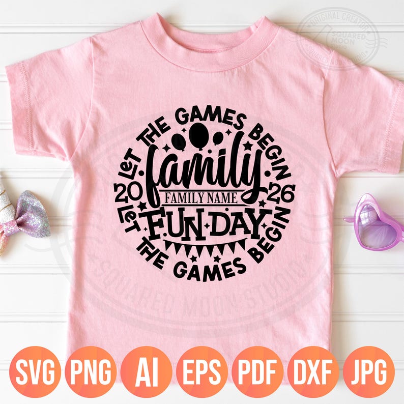 May include: A light pink t-shirt with a black circular design that reads "Let the Games Begin" around the word "Family". The design includes balloons, stars, and a banner. The bottom of the shirt has the file types: SVG, PNG, AI, EPS, PDF, DXF, and JPG.