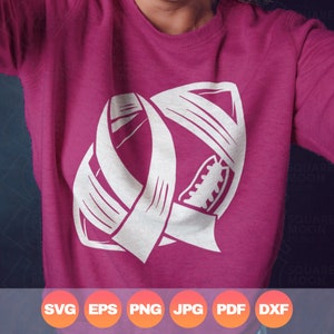 May include: A pink sweatshirt with a white outline of an American football with a ribbon wrapped around it.