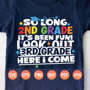 May include: A navy blue t-shirt with a colorful graphic that says "So long. 2nd grade it's been fun! Look out 3rd grade here I come". The graphic is in rainbow colors with a graduation cap at the top. The shirt has a white background and the text is in white.