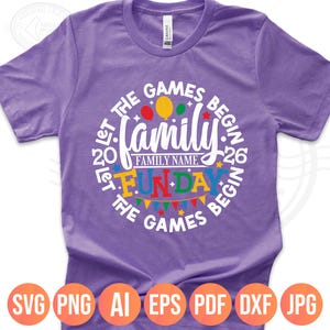 May include: A purple t-shirt with a circular design that reads "Let the Games Begin" around the edge. The design includes the word "Family" and "Fun Day" with colorful balloons and pennants. The bottom of the shirt shows file type icons.