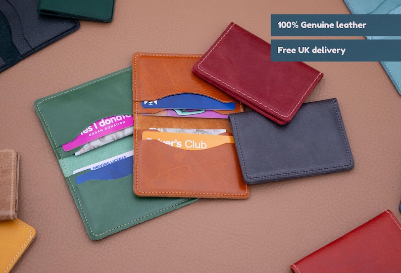 May include: Assortment of leather card holders in various colors, including green, brown, red, and blue. The card holders have multiple slots for holding cards and are made of genuine leather. The text "100% Genuine leather" and "Free UK delivery" is visible in the image.