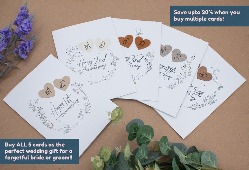 K&ouml;nnte beinhalten: Satz von f&uuml;nf wei&szlig;en Karten mit einem floralen Design und braunen herzf&ouml;rmigen Verzierungen. Jede Karte zeigt eine andere Jubil&auml;umszahl von 1. bis 5. Der Text "Happy [Jubil&auml;umszahl] Anniversary" ist auf jeder Karte gedruckt.