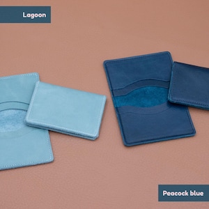 May include: Two leather card holders, one in a light blue color called "Lagoon" and the other in a darker blue color called "Peacock blue".