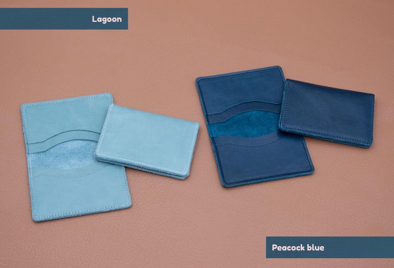 May include: Two leather card holders, one in a light blue color called "Lagoon" and the other in a darker blue color called "Peacock blue".
