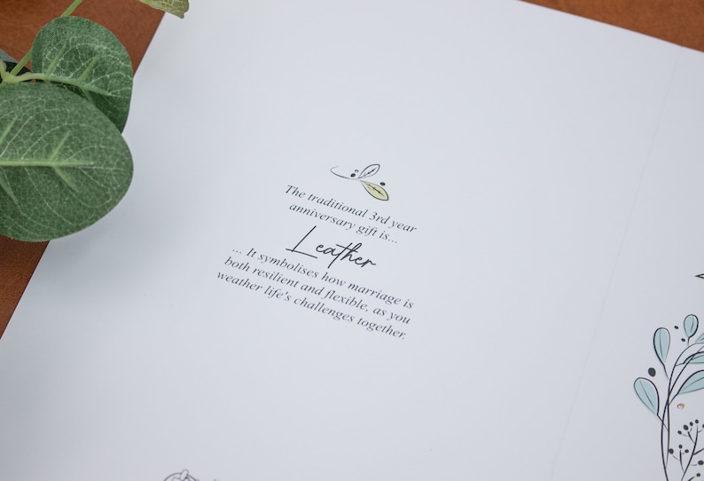 K&ouml;nnte beinhalten: Eine wei&szlig;e Karte mit dem Text "Das traditionelle Geschenk zum 3. Hochzeitstag ist... Leder... Es symbolisiert, wie widerstandsf&auml;hig und flexibel die Ehe ist, da Sie gemeinsam die Herausforderungen des Lebens meistern."