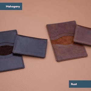 May include: Two leather card holders, one in mahogany and one in rust. Both have a suede interior and a single pocket.