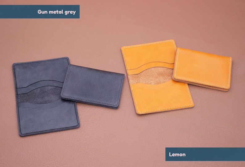 May include: Two leather wallets, one in gunmetal grey and one in lemon yellow. Both wallets have a similar design with two pockets and a suede lining.