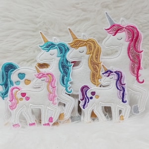 Könnte beinhalten: Fünf gestickte Einhorn-Patches in verschiedenen Farben, darunter Pink, Blau, Lila und Gold. Die Einhörner sind alle nach vorne gerichtet und haben die Augen geschlossen. Die Patches sind perfekt, um jedem Projekt eine verspielte Note zu verleihen.