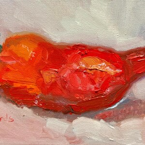 May include: Oil painting of a ripe tomato with a green stem. The tomato is a vibrant red and orange, with visible brushstrokes and texture. The artist's signature, "T. Richards", is in the lower left corner. The background is a soft, neutral color.
