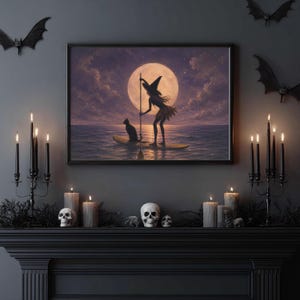 May include: A framed wall art print depicting a silhouette of a witch in a pointed hat and a cat on a paddleboard on the water under a large full moon. The scene is set against a dark purple and cloudy sky, capturing a serene night atmosphere.