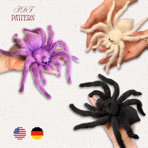Könnte beinhalten: Drei handgefertigte, plüschige Spinnen in Lila, Creme und Schwarz. Die Spinnen haben lange, flauschige Beine und kleine Augen. Das Bild enthält den Text "PDF PATTERN" sowie amerikanische und deutsche Flaggen.