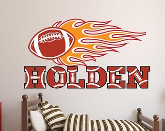 Könnte beinhalten: Ein rot-weißer Fußball mit Flammen dahinter und dem Namen "HOLDEN" in roten Buchstaben mit weißen Fußballnähten.