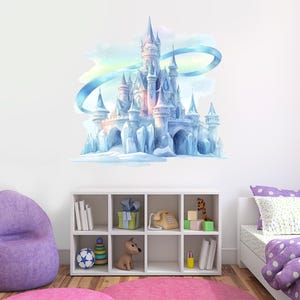 May include: A watercolor wall decal of a fairytale castle in shades of blue, pink, and white. The castle features multiple turrets and is set against a backdrop of a blue and rainbow-colored sky. The decal is mounted on a white wall.