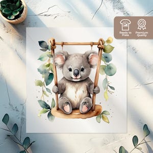 Peut inclure: Une illustration aquarelle d'un koala assis sur une balançoire entourée de feuilles vertes. Le koala est gris avec un nez brun clair et des oreilles roses.